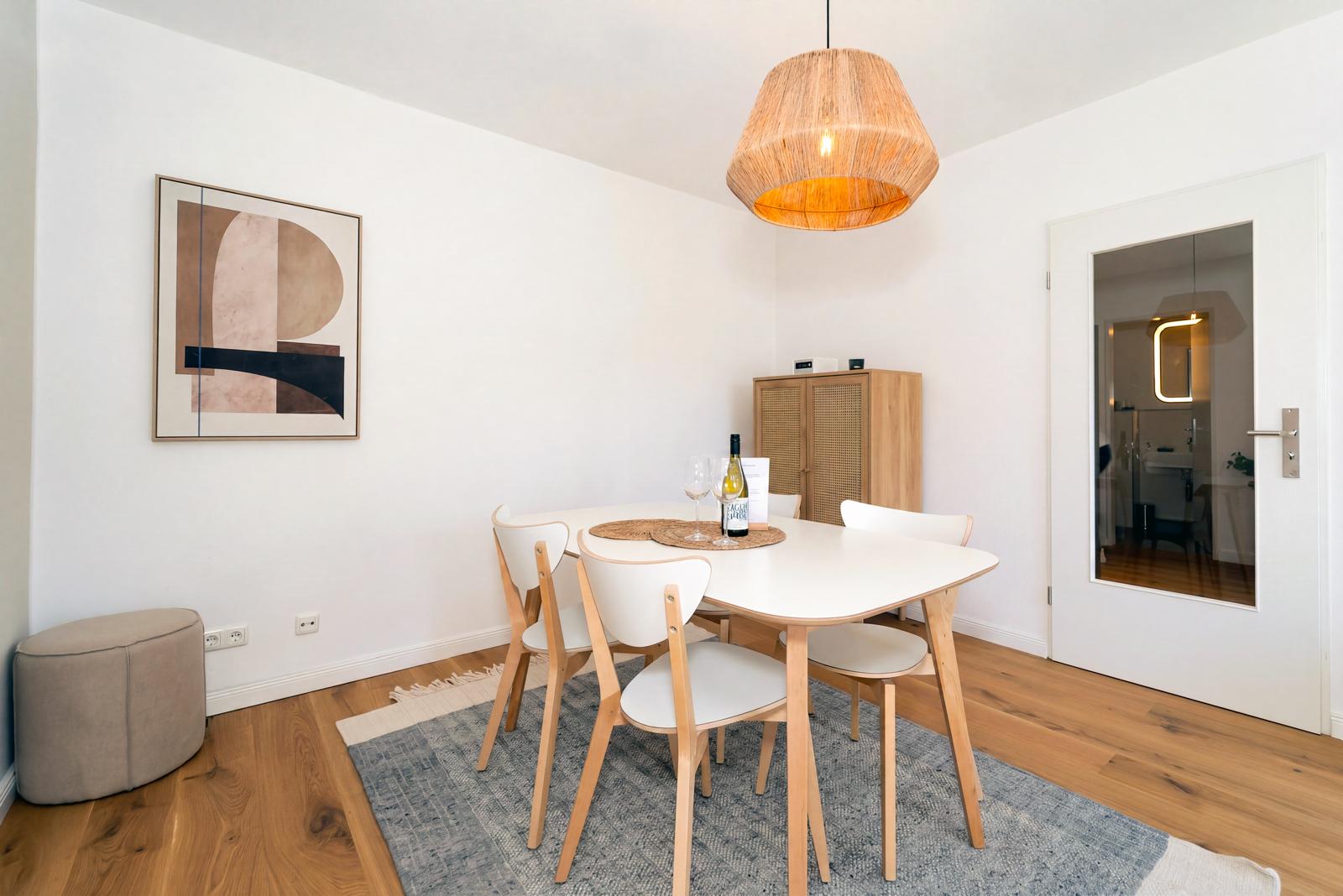 Essbereich mit weißem Tisch und Rattan-Schrank