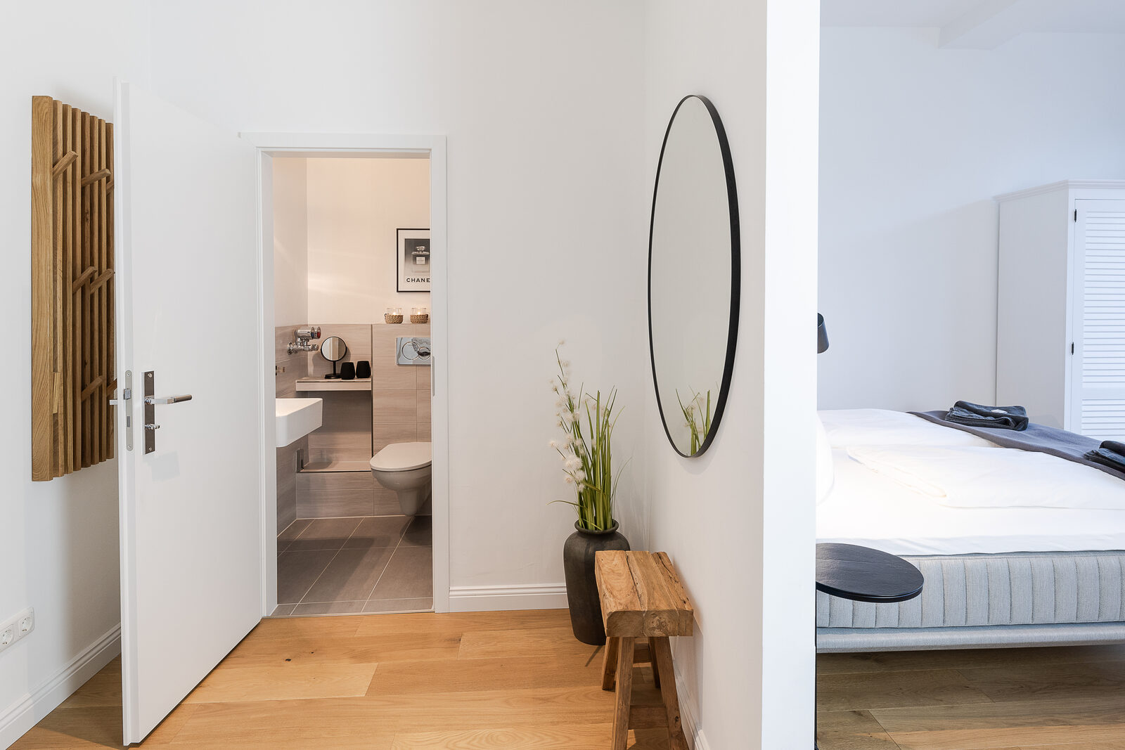 Flur mit Garderobe, Spiegel und Blick ins Bad