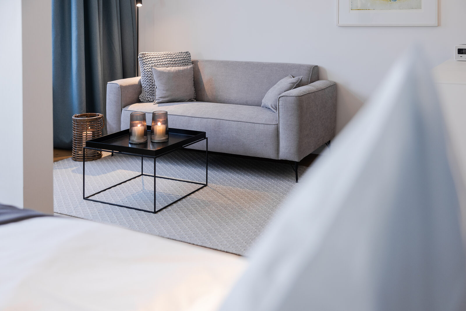 Blick vom Bett auf das Sofa mit Kerzenlicht